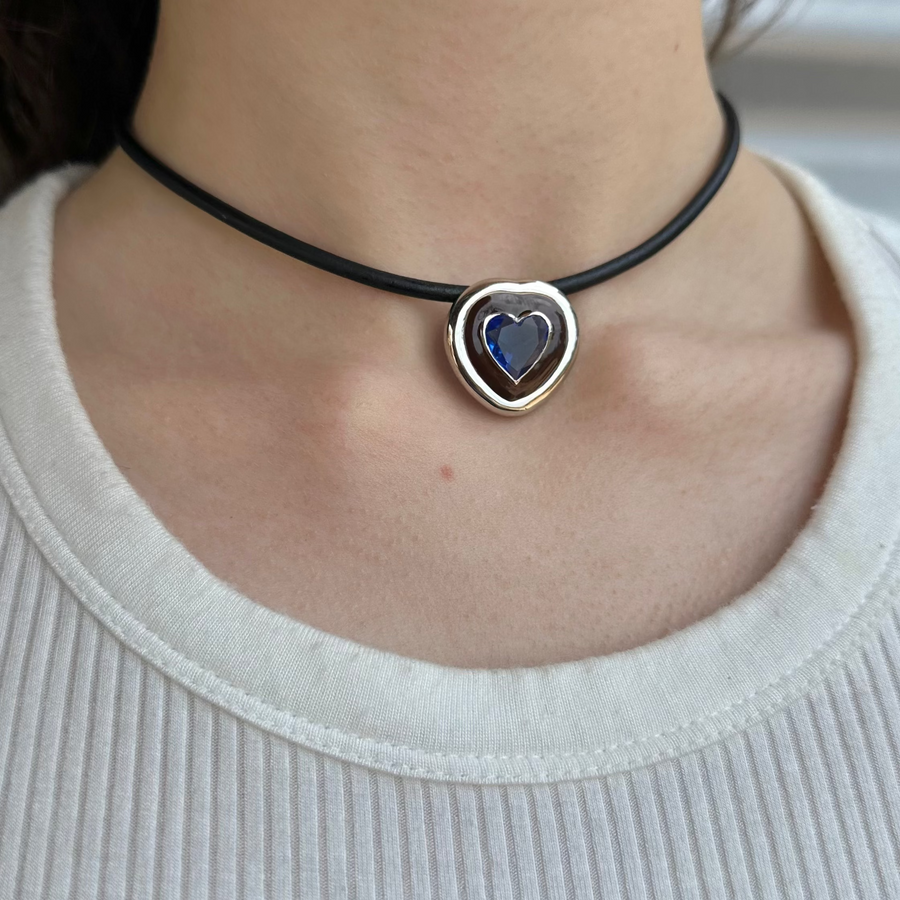 Necklace with a heart-shaped pendant worn by a person