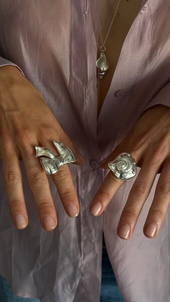 Rings and a shell necklace worn together