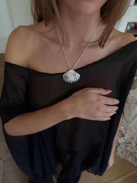 The shell necklace worn with a black top